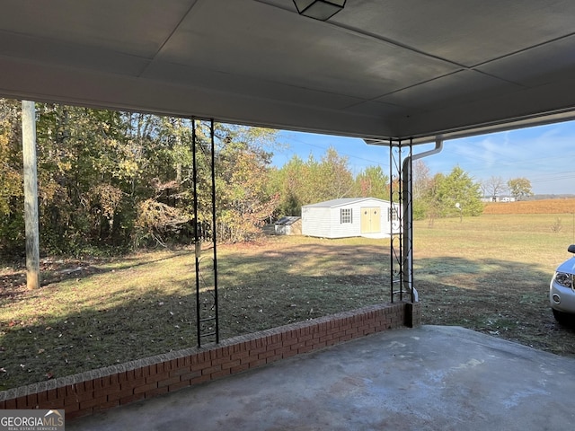 view of yard featuring a shed and a patio