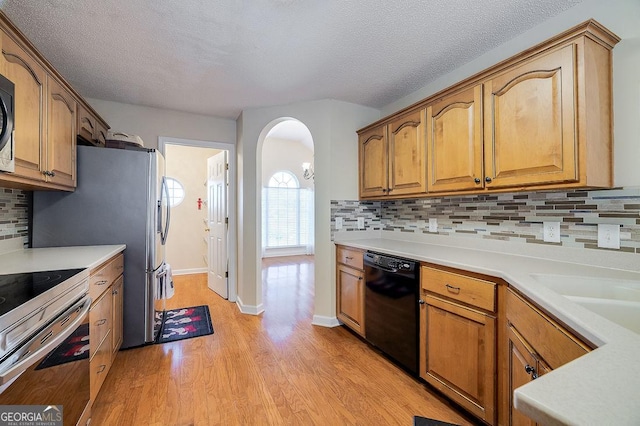 kitchen with backsplash, stainless steel electric stove, dishwasher, a textured ceiling, and light hardwood / wood-style flooring