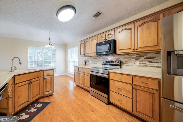 kitchen featuring tasteful backsplash, a notable chandelier, sink, hanging light fixtures, and appliances with stainless steel finishes