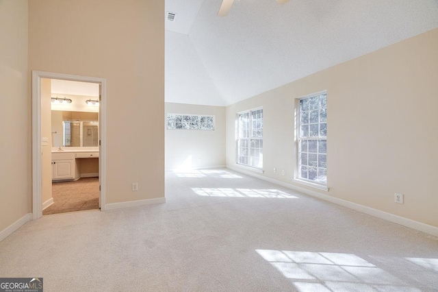 empty room featuring light carpet and vaulted ceiling