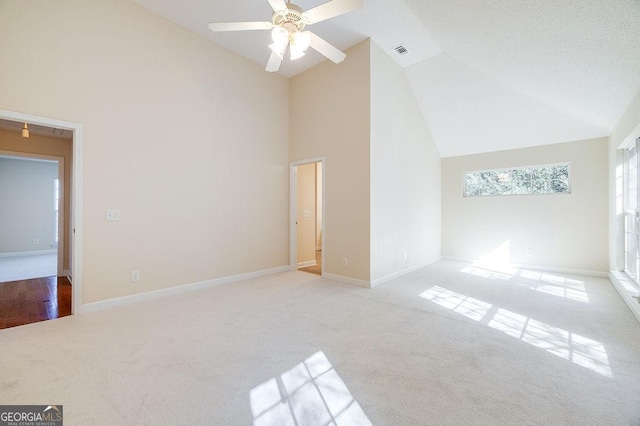 interior space featuring ceiling fan, light colored carpet, a textured ceiling, and high vaulted ceiling