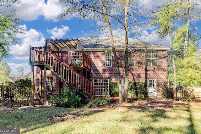 back of property with a wooden deck, a lawn, and a pergola