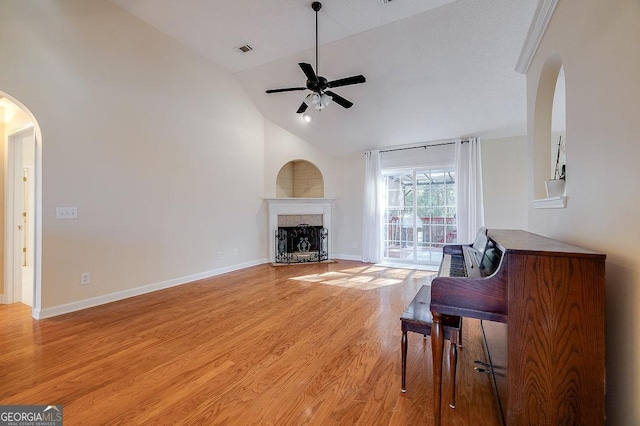 living room featuring light wood-type flooring, vaulted ceiling, and ceiling fan