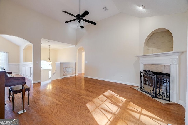 living room with ceiling fan, a tile fireplace, and hardwood / wood-style floors