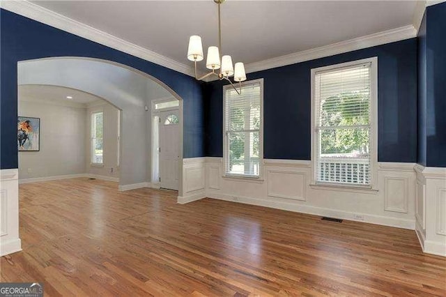 interior space with an inviting chandelier, crown molding, and hardwood / wood-style flooring