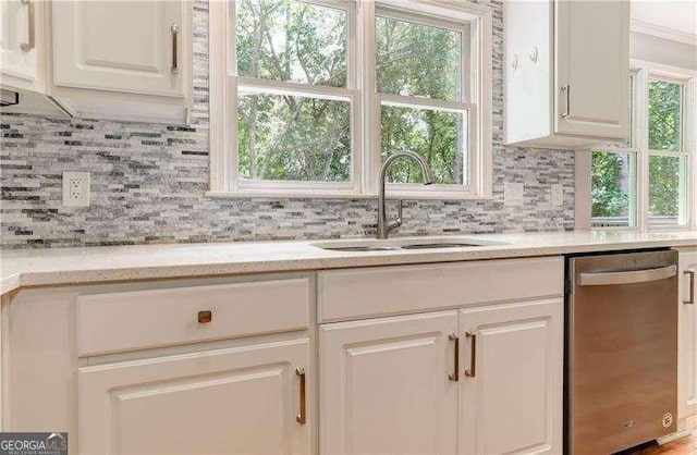 kitchen with decorative backsplash, dishwasher, white cabinets, and sink