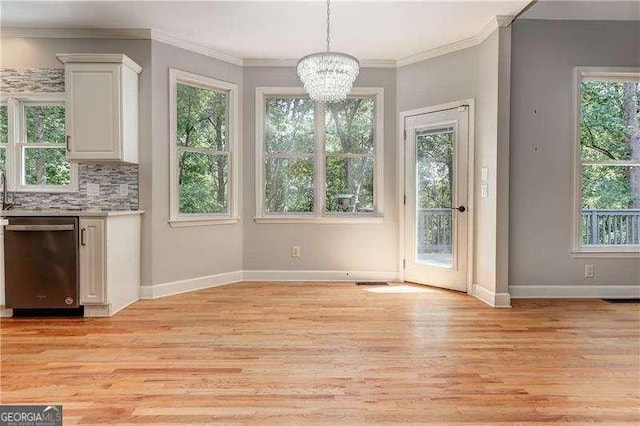 unfurnished dining area with a healthy amount of sunlight, an inviting chandelier, and ornamental molding