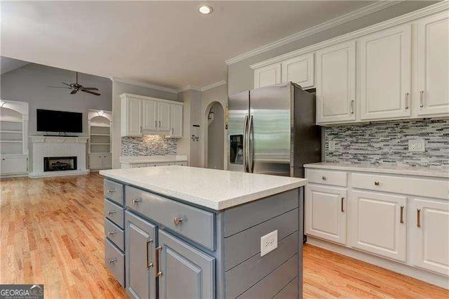 kitchen featuring ceiling fan, backsplash, white cabinetry, gray cabinetry, and stainless steel fridge