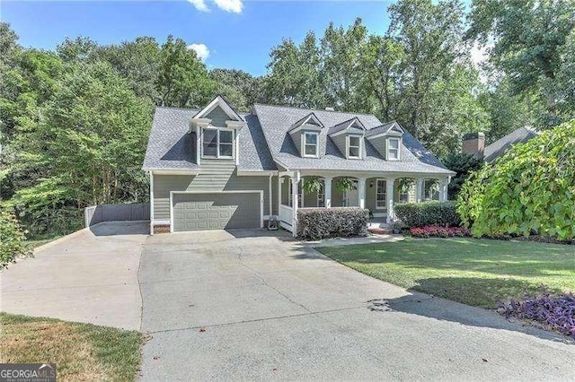 cape cod house featuring a front yard, a garage, and a porch