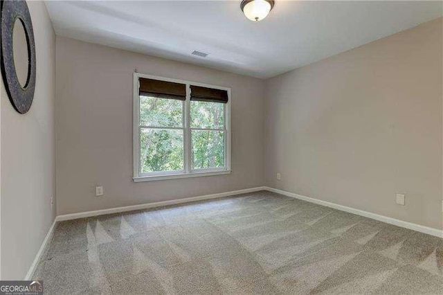 spare room featuring light colored carpet