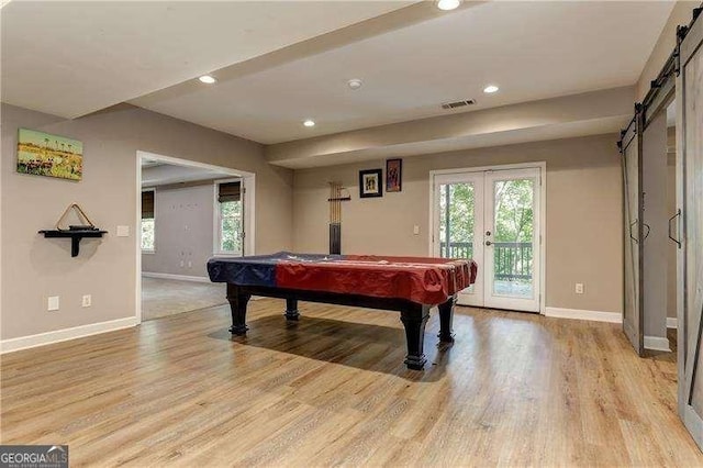 playroom with light wood-type flooring, billiards, french doors, and a barn door