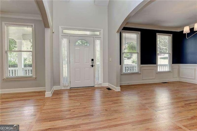 foyer entrance featuring light wood-type flooring and ornamental molding