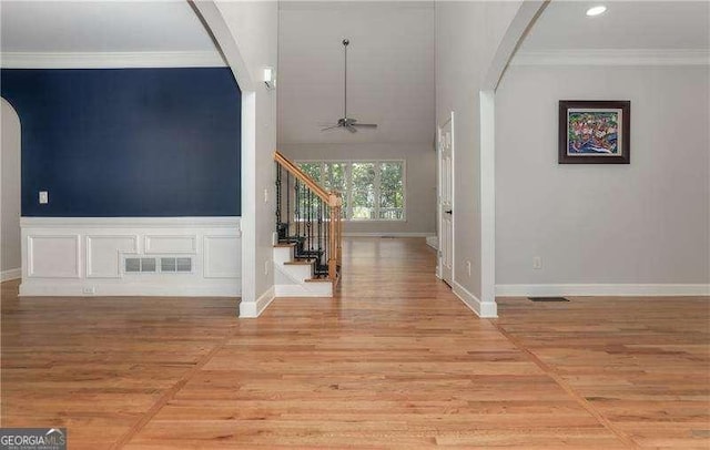 foyer featuring ceiling fan, crown molding, and light hardwood / wood-style floors