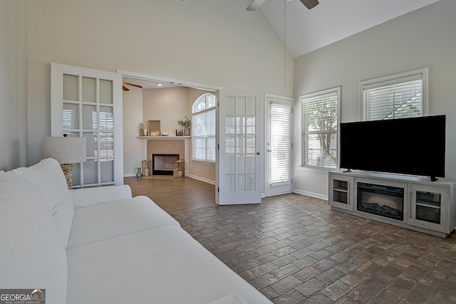 living room featuring ceiling fan and high vaulted ceiling