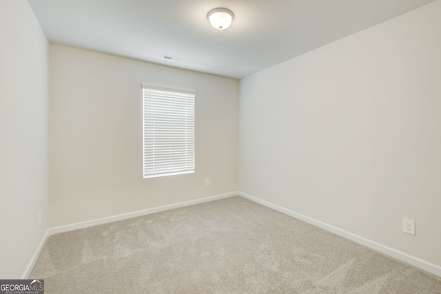 spare room featuring light colored carpet