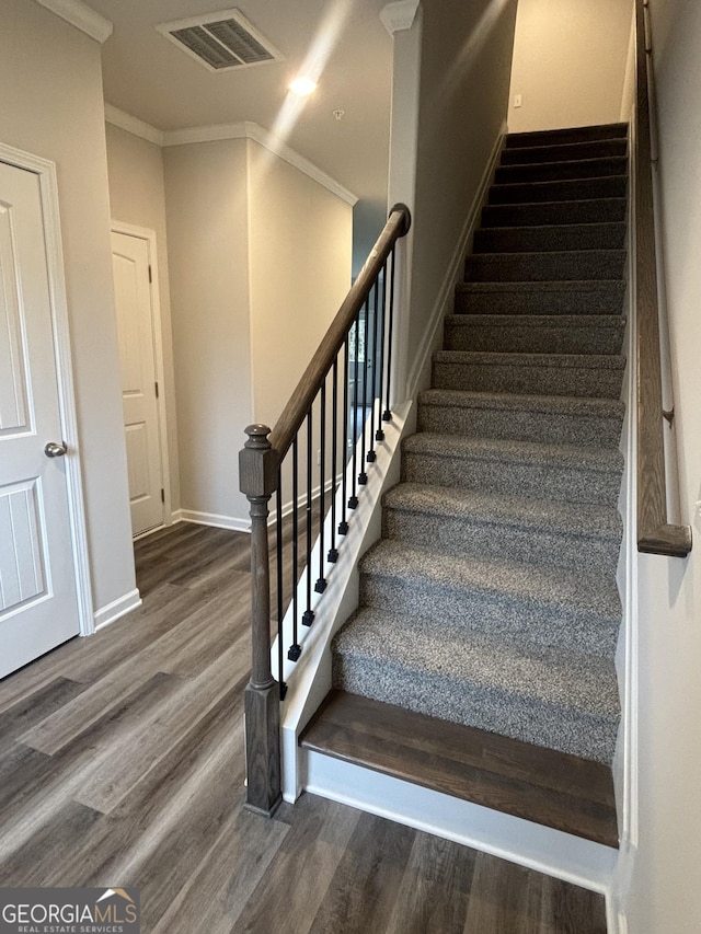 staircase with hardwood / wood-style floors and crown molding