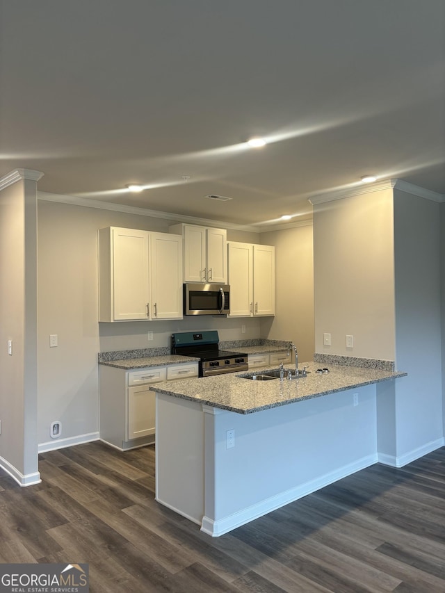 kitchen with white cabinetry, kitchen peninsula, appliances with stainless steel finishes, dark hardwood / wood-style floors, and sink