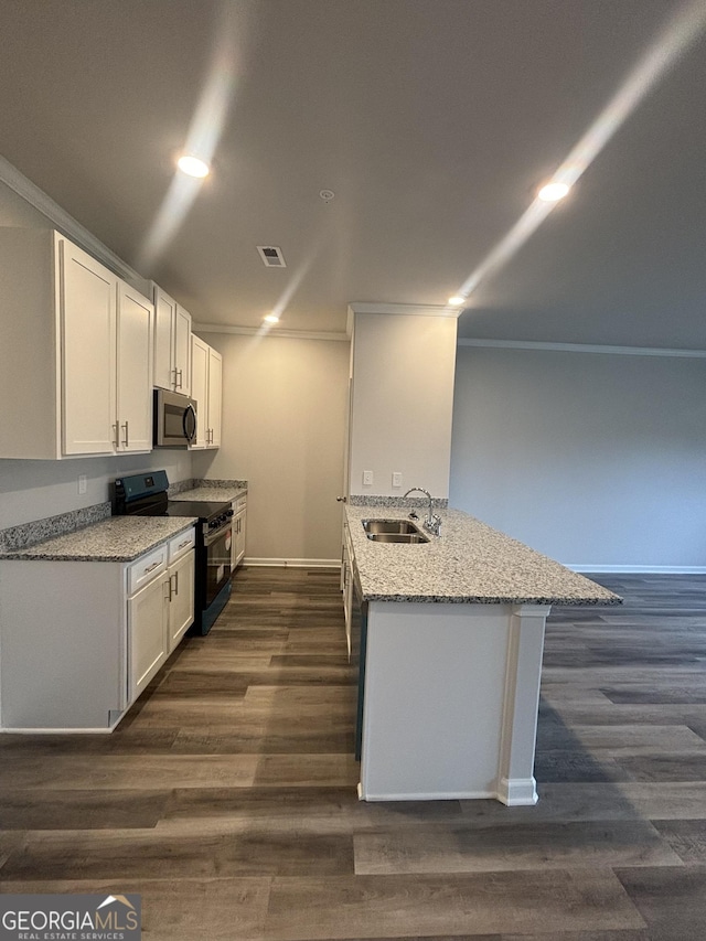 kitchen featuring kitchen peninsula, black electric range oven, white cabinets, and sink