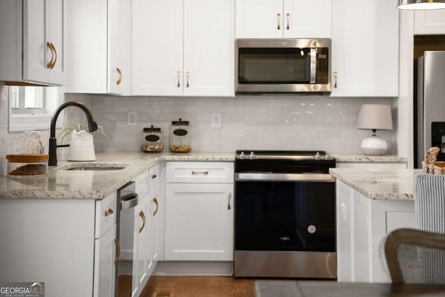 5721 Brickhampton Ct, Clermont, GA 30527 - kitchen with appliances with stainless steel finishes, a sink, white cabinets, and tasteful backsplash