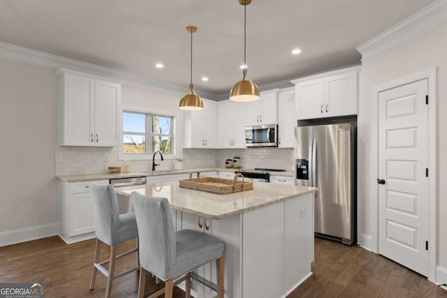 kitchen featuring light stone countertops, a center island, white cabinetry, stainless steel appliances, and sink