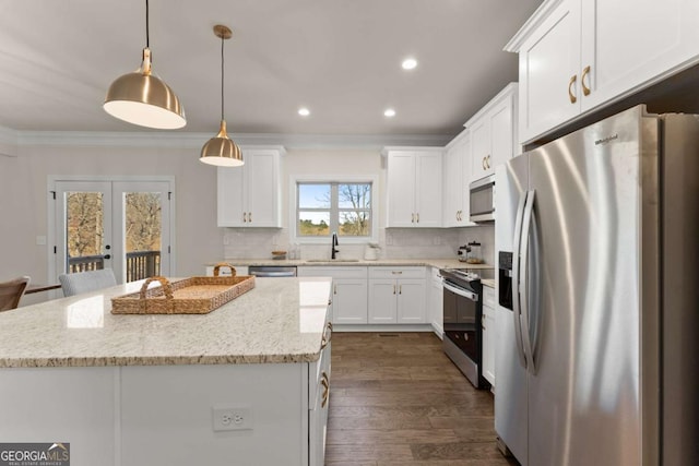 kitchen featuring appliances with stainless steel finishes, french doors, light stone countertops, pendant lighting, and a center island