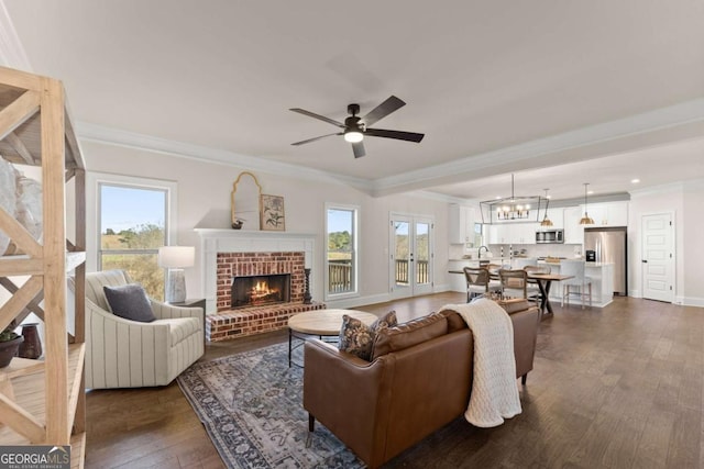 5721 Brickhampton Ct, Clermont, GA 30527 - living area with crown molding, dark wood finished floors, a brick fireplace, ceiling fan, and baseboards