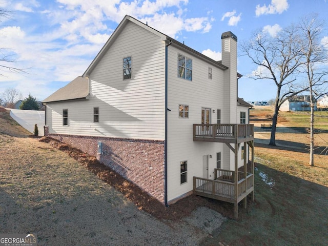 5721 Brickhampton Ct, Clermont, GA 30527 - view of property exterior featuring a chimney, brick siding, a wooden deck, and a balcony