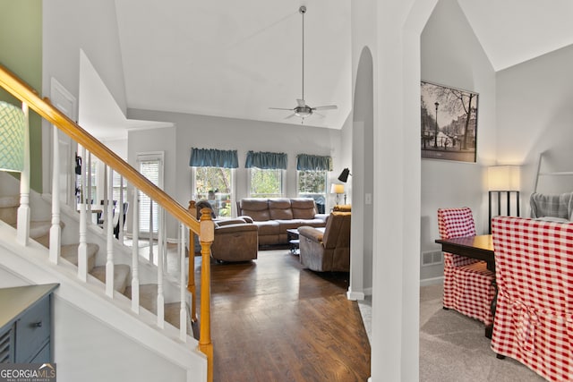 living room with dark hardwood / wood-style flooring, high vaulted ceiling, and ceiling fan