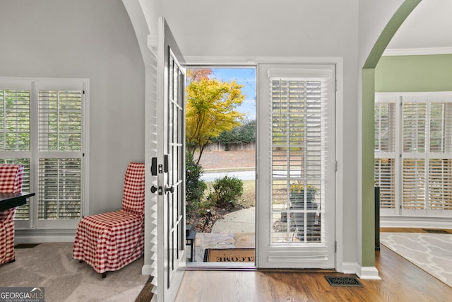 doorway to outside featuring crown molding and hardwood / wood-style floors