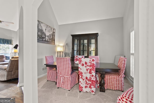 dining area with high vaulted ceiling, carpet floors, and ceiling fan