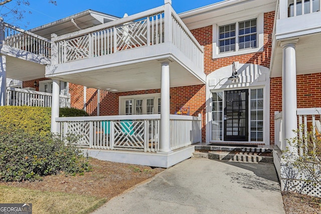 885 Briarcliff Rd NE Unit 21, Atlanta, GA 30306 - doorway to property with brick siding, a porch, and a balcony