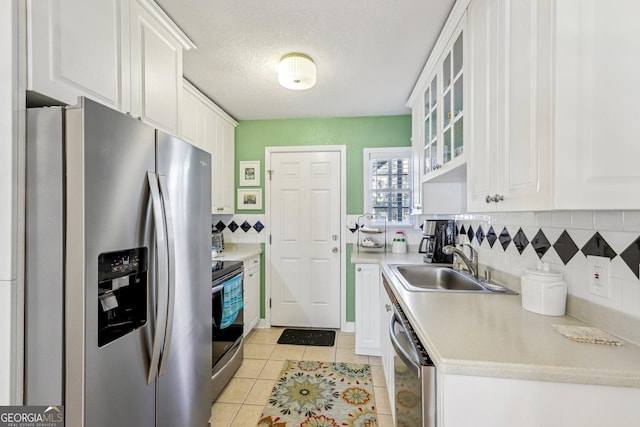 885 Briarcliff Rd NE Unit 21, Atlanta, GA 30306 - kitchen featuring stainless steel appliances, a sink, white cabinets, backsplash, and a textured ceiling