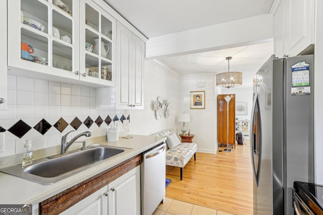 885 Briarcliff Rd NE Unit 21, Atlanta, GA 30306 - kitchen with stainless steel appliances, a sink, white cabinetry, decorative backsplash, and glass insert cabinets