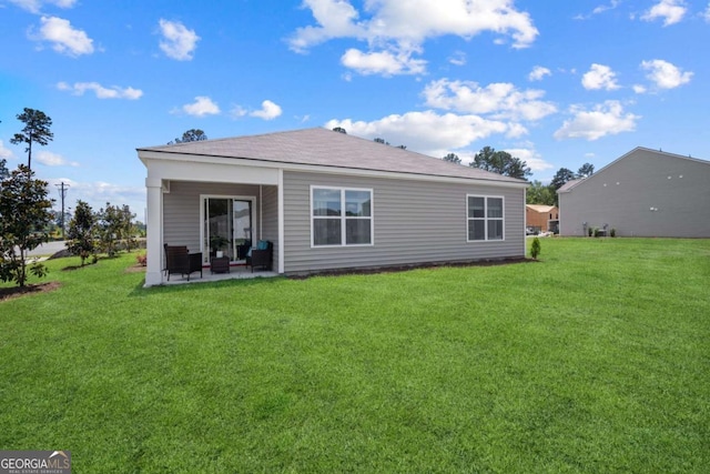 rear view of property featuring a patio area and a lawn