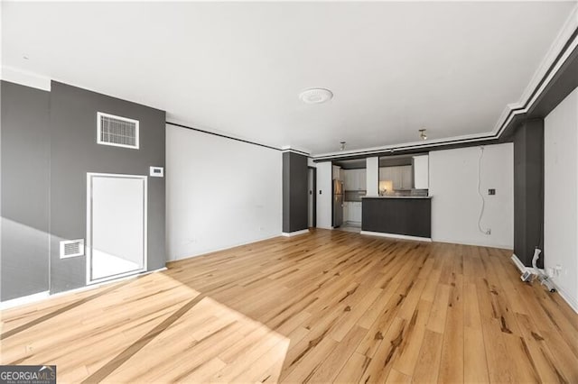 unfurnished living room featuring visible vents and light wood-style flooring