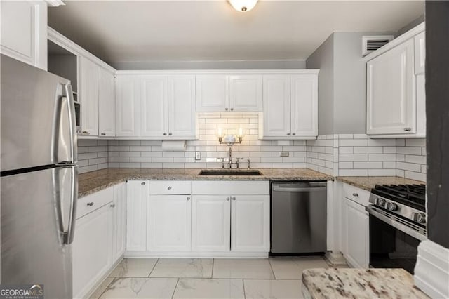 kitchen featuring light stone counters, a sink, white cabinetry, marble finish floor, and appliances with stainless steel finishes