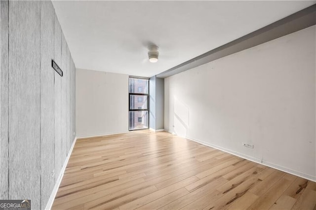 empty room with light wood-style floors and floor to ceiling windows