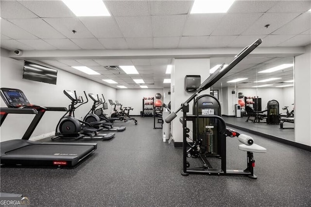 gym with a drop ceiling, visible vents, and baseboards