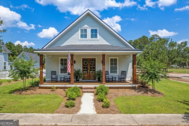 bungalow featuring covered porch and a front lawn