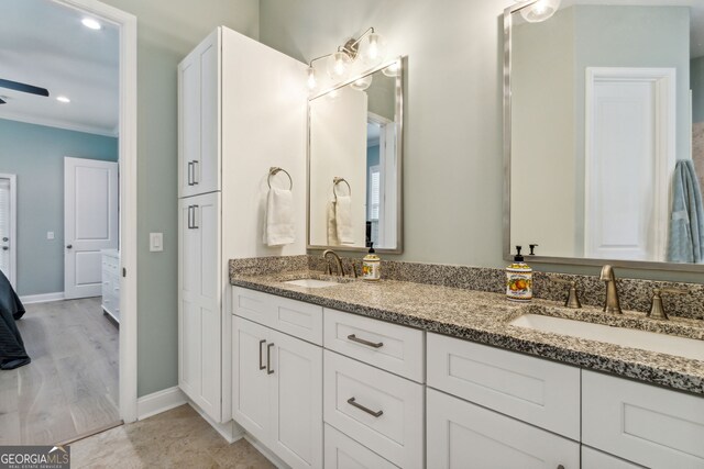 bathroom featuring ceiling fan, vanity, and ornamental molding