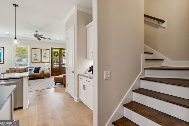 stairway featuring ceiling fan, hardwood / wood-style floors, and ornamental molding