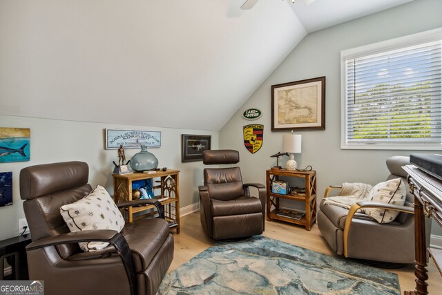 living area with ceiling fan, lofted ceiling, and light hardwood / wood-style floors