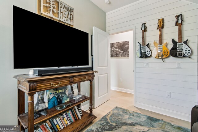 interior space with light hardwood / wood-style floors and wooden walls