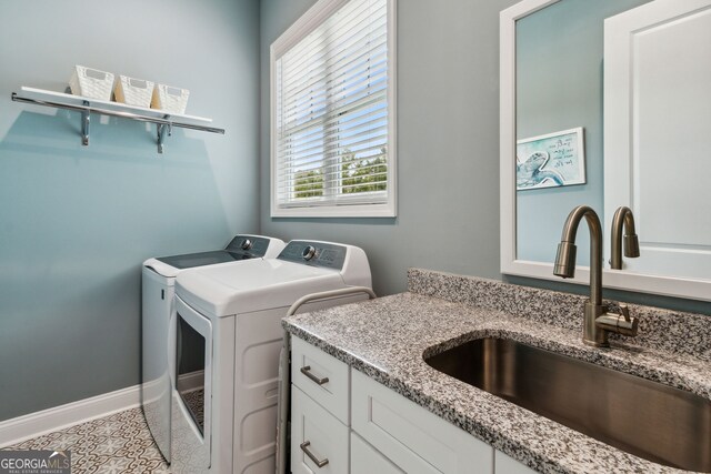 clothes washing area with washer and clothes dryer, sink, and light tile patterned floors