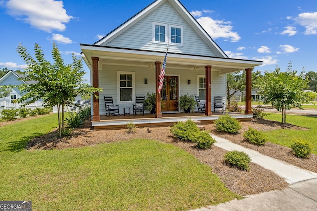 bungalow featuring covered porch and a front lawn