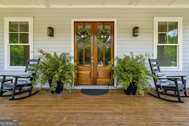 doorway to property featuring a porch and french doors