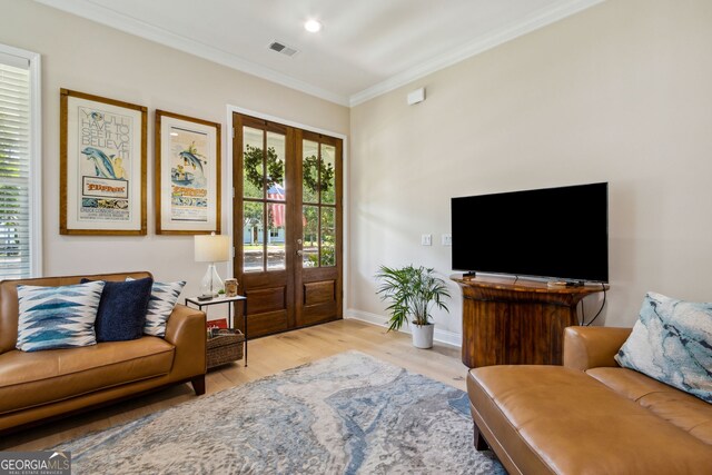 living room featuring french doors, crown molding, and light hardwood / wood-style flooring