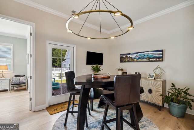 dining space featuring light hardwood / wood-style floors and crown molding