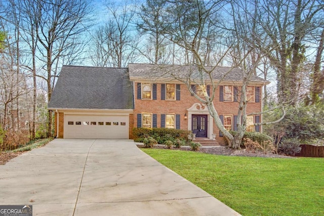 colonial-style house featuring a garage and a front yard