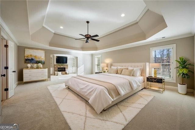 carpeted bedroom featuring ornamental molding, a raised ceiling, and ceiling fan